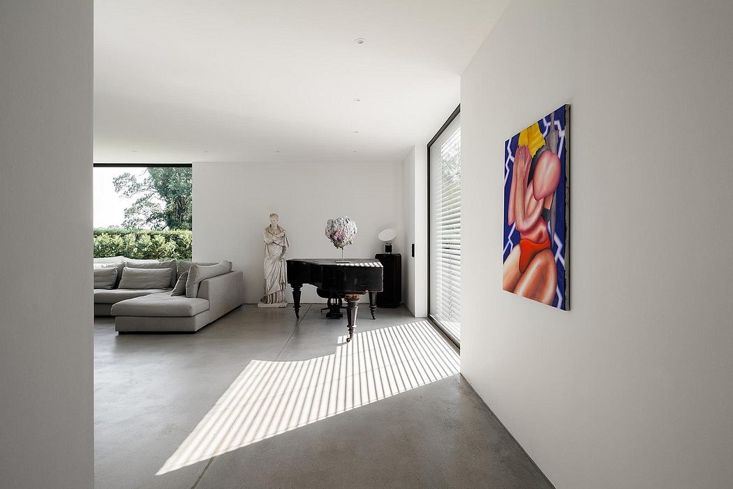 Minimalist living room with modern decor, abstract art, and grand piano against white walls.