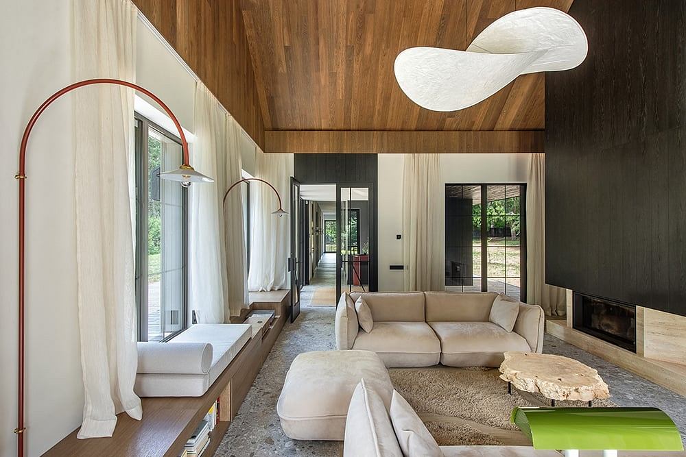 Luxurious modern living room with wood-paneled walls, stylish lighting, and cozy furnishings.