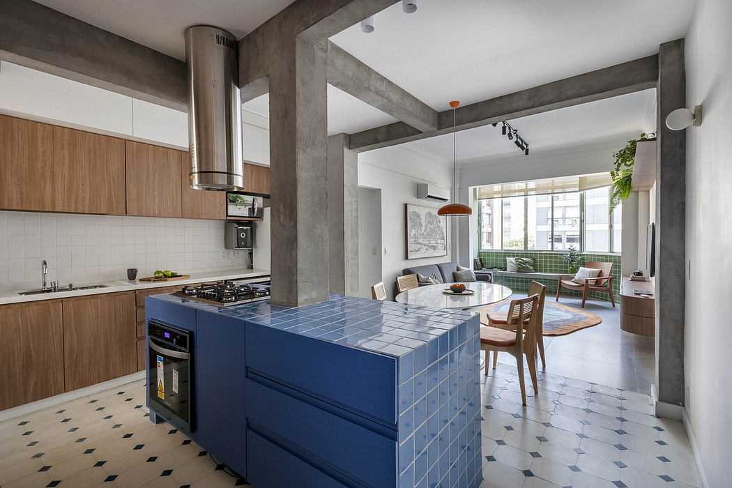 Modern, open-plan kitchen with blue tiled island, exposed concrete beams, and integrated living space.