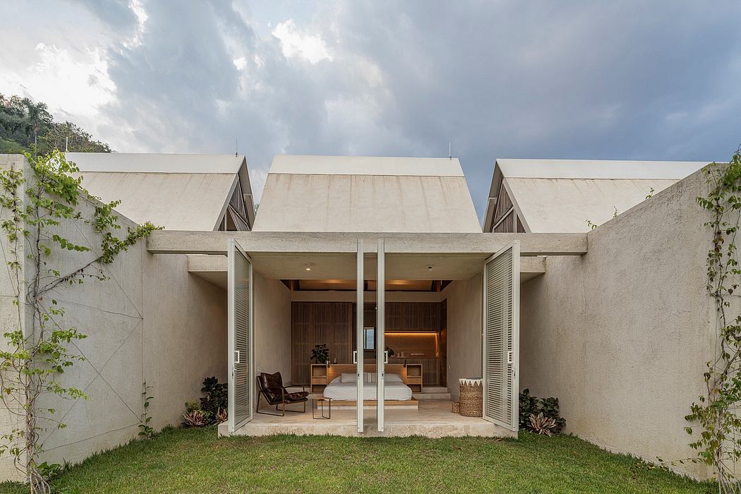 Minimalist, open-concept home design with sliding glass doors, stone walls, and lush greenery.