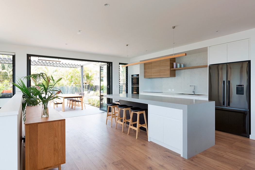 Spacious modern kitchen with wood accents, large windows, and an open floor plan.