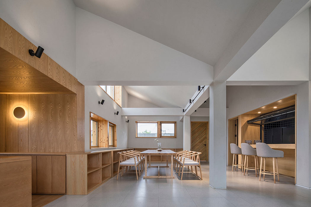 A spacious, modern interior with exposed wooden beams, minimalist furniture, and a warm, inviting atmosphere.