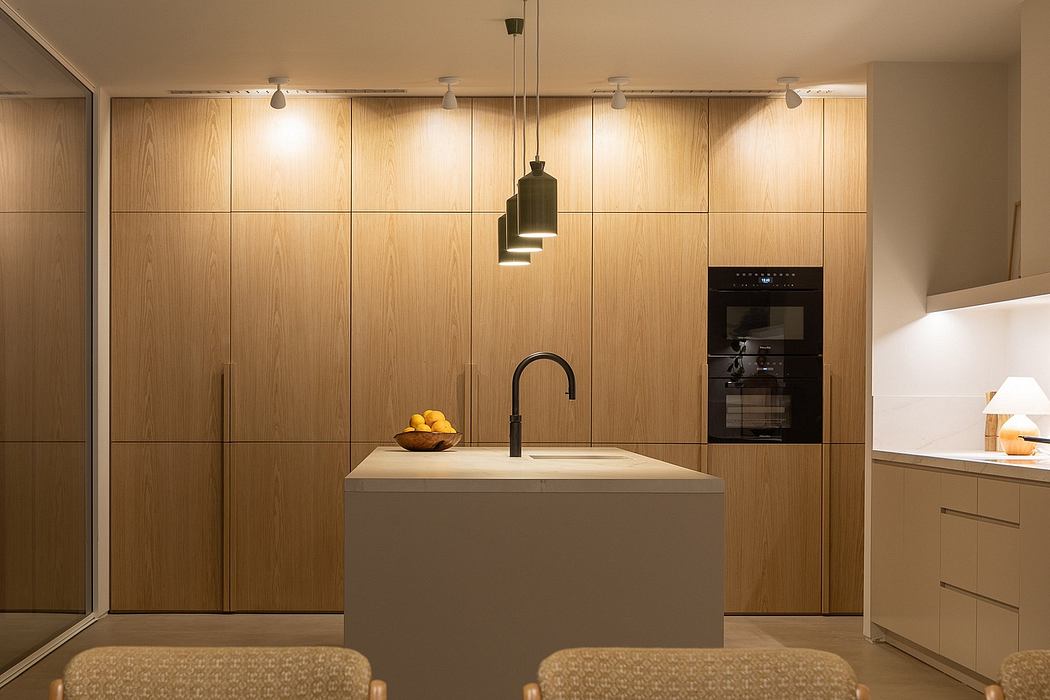 Modern kitchen with wooden cabinetry, sleek sink, and pendant lighting accents.