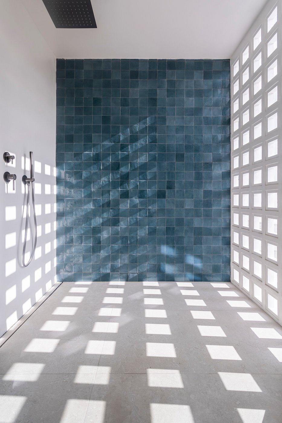 A modern bathroom with a striking tiled wall, creating a dynamic, contemporary space.