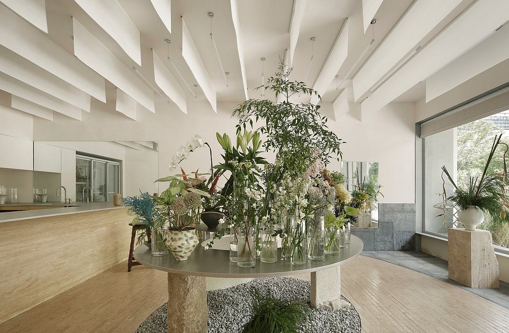 A modern, open-concept living space with a striking floral centerpiece on a round table.