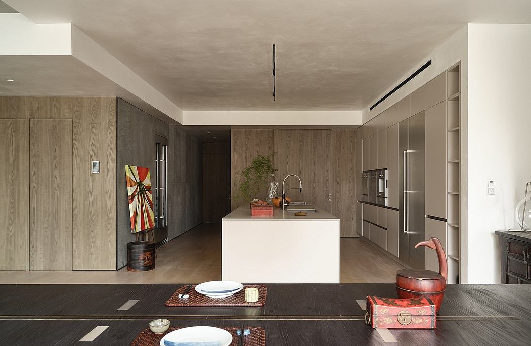 A modern, minimal kitchen with wood-paneled walls, sleek white island, and contemporary decor.