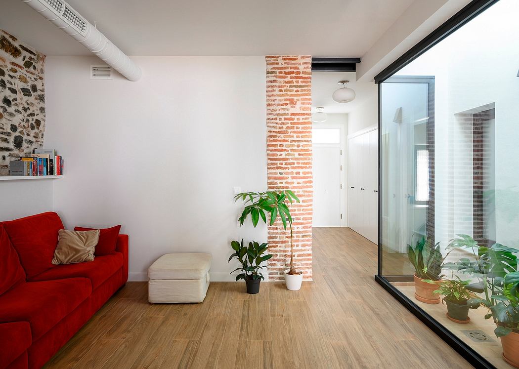 Bright, modern interior with red sofa, wooden floors, and brick accent wall.