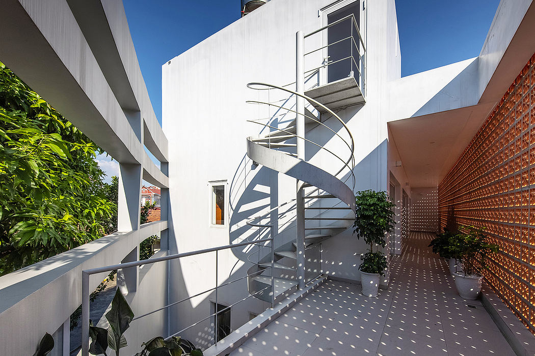 Striking spiral staircase surrounded by lush greenery and modern architectural elements.