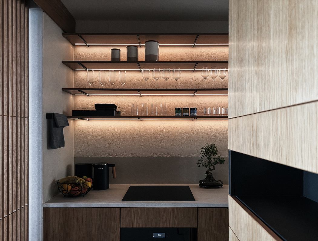 A modern, minimalist home bar with wooden shelves, overhead lighting, and a bonsai plant.