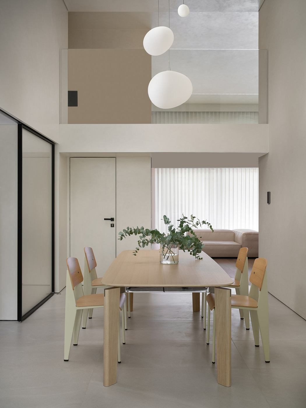 Minimalist dining room with wooden table, chairs, and hanging white globe lights.