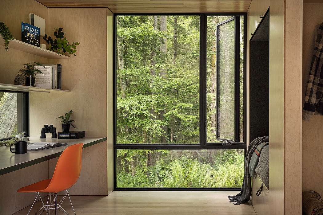 Cozy woodland retreat with floor-to-ceiling windows showcasing lush green foliage.