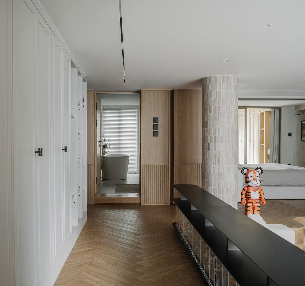 Modern, minimalist hallway with wood paneling, tiled column, and a playful tiger figurine.