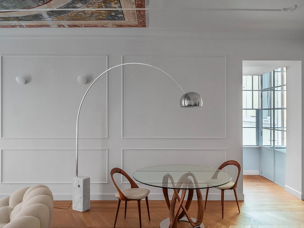 Modern dining area with circular glass-topped table, wooden chairs, and architectural wall panels.