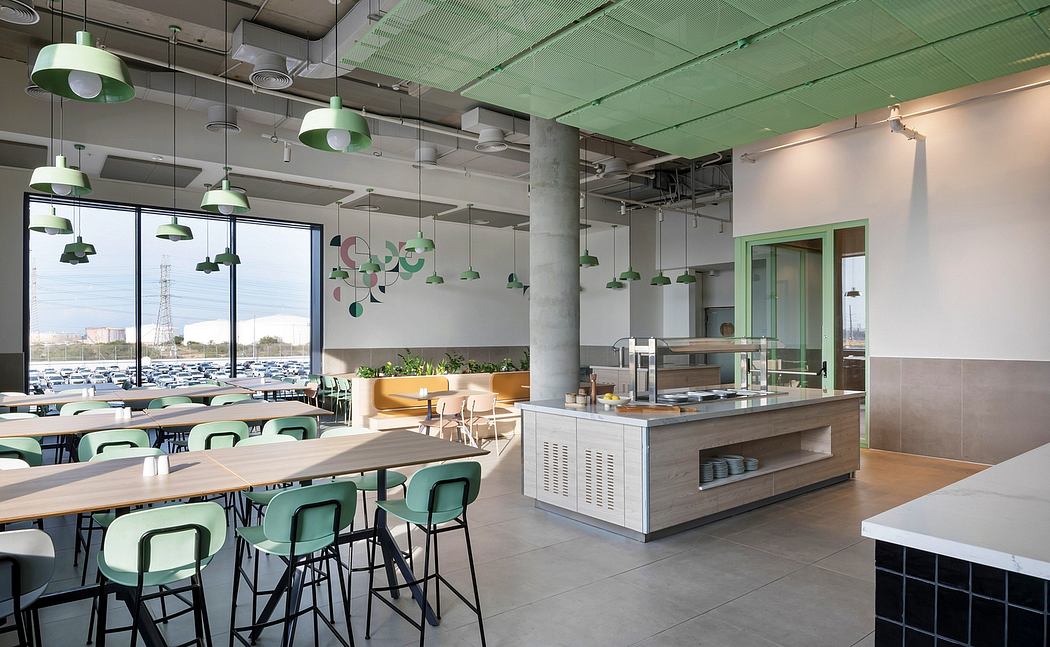 Modern open workspace with green accents, industrial lighting, and a minimalist kitchen island.