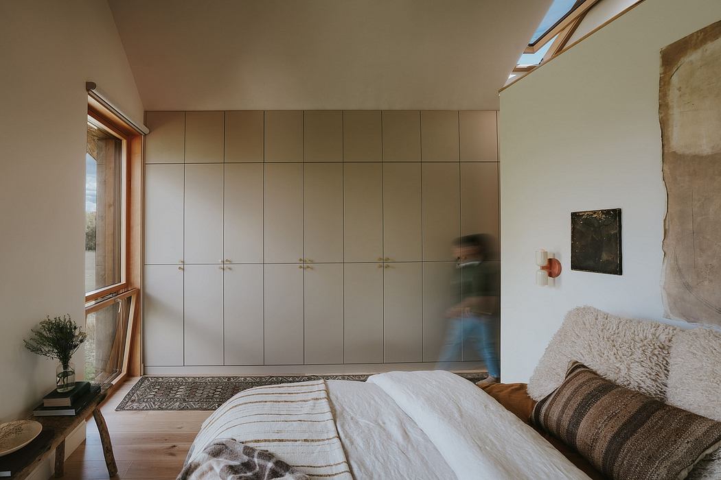 Cozy bedroom with floor-to-ceiling closet wall, textured rug, and natural light.