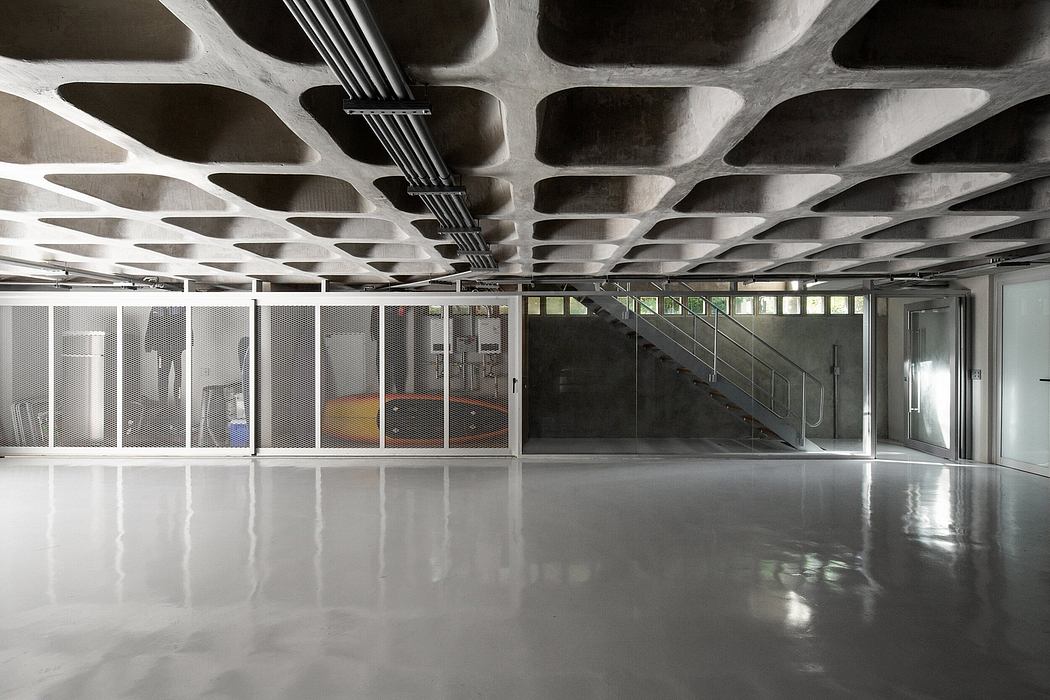 Dramatic, gridded concrete ceiling and glass partitions in minimalist interior.