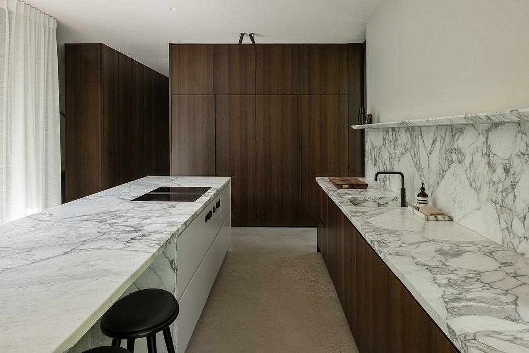A modern kitchen with dark wood cabinetry, marble countertops, and a central island.