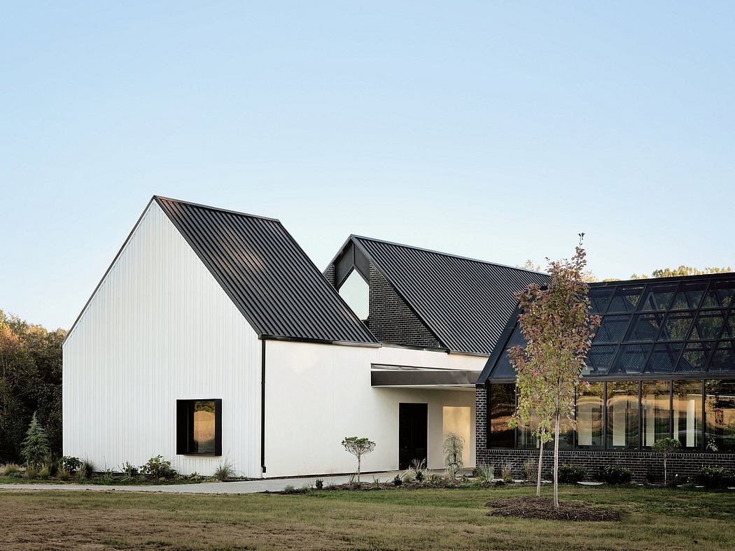 Striking modern farmhouse design with black metal roof and expansive glass facade.