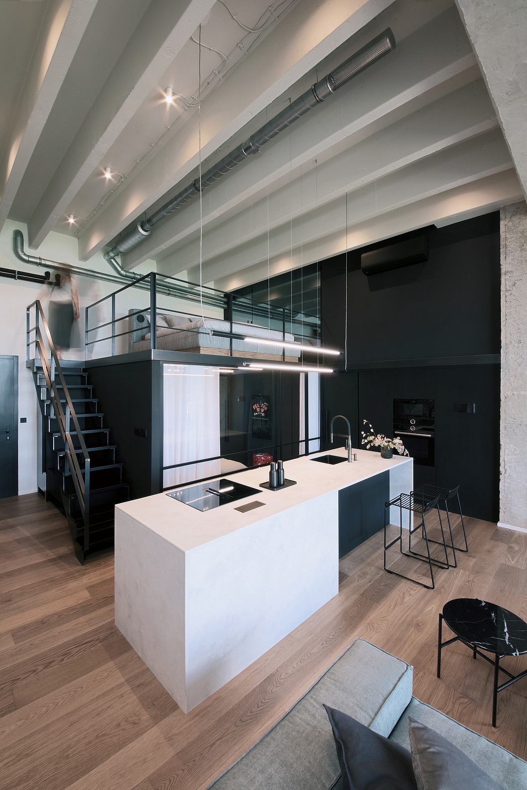 Sleek industrial-style loft with open kitchen, concrete walls, and modern furniture.