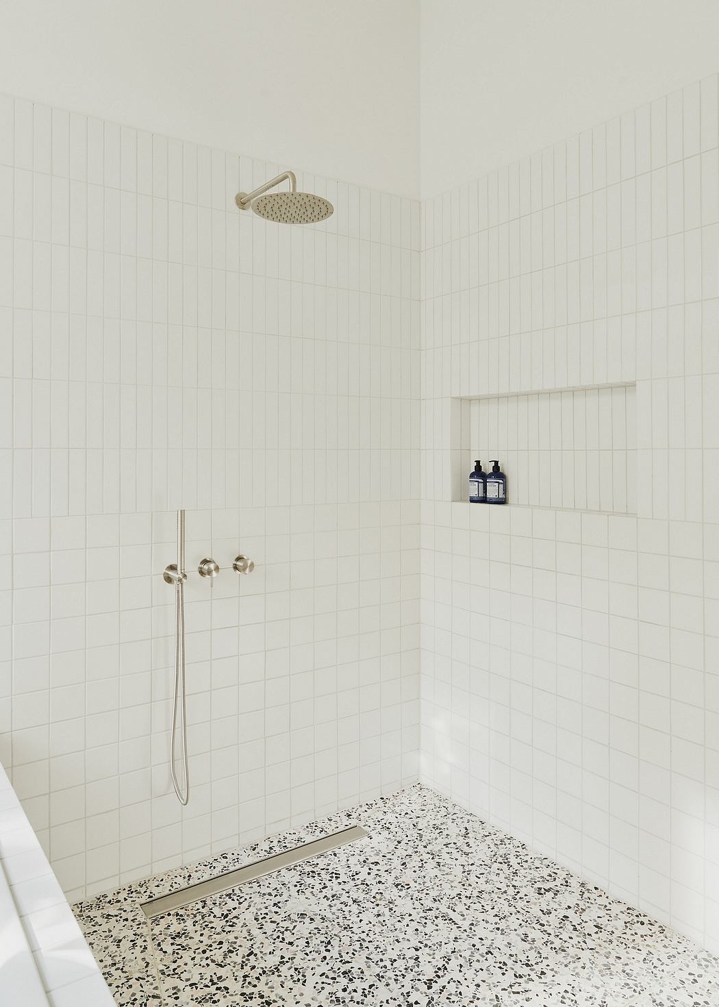 Minimalist bathroom design featuring a tiled shower area with a rain showerhead.