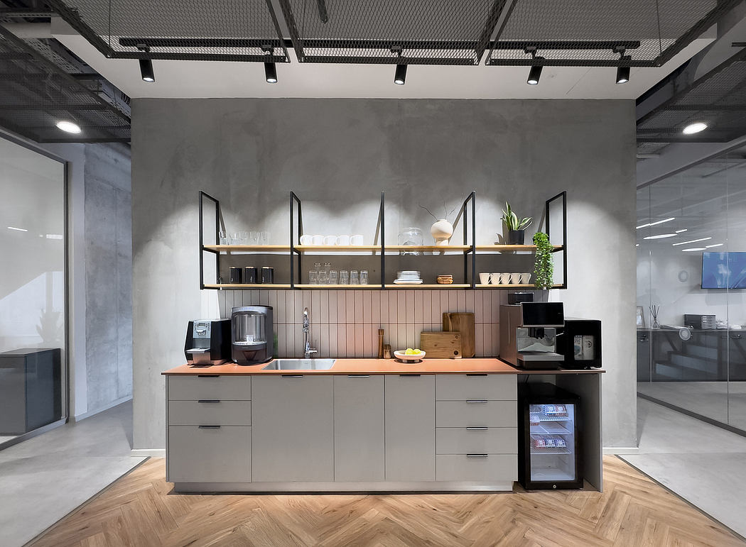 Modern minimalist kitchen with concrete walls, wooden shelves, and sleek gray cabinets.