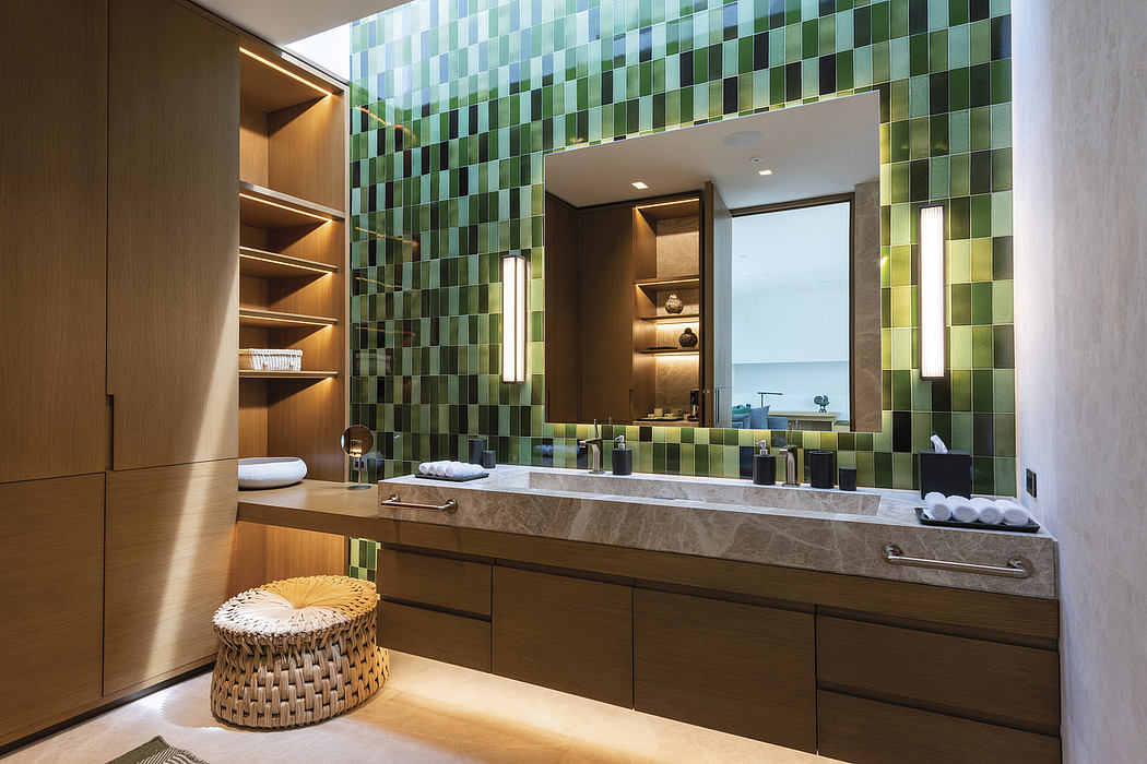 Striking green tile wall, natural stone vanity, and recessed shelving in modern bathroom.