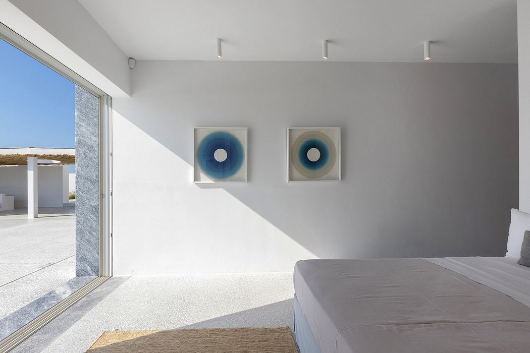 Minimalist bedroom with modern artwork and sliding glass door to balcony.