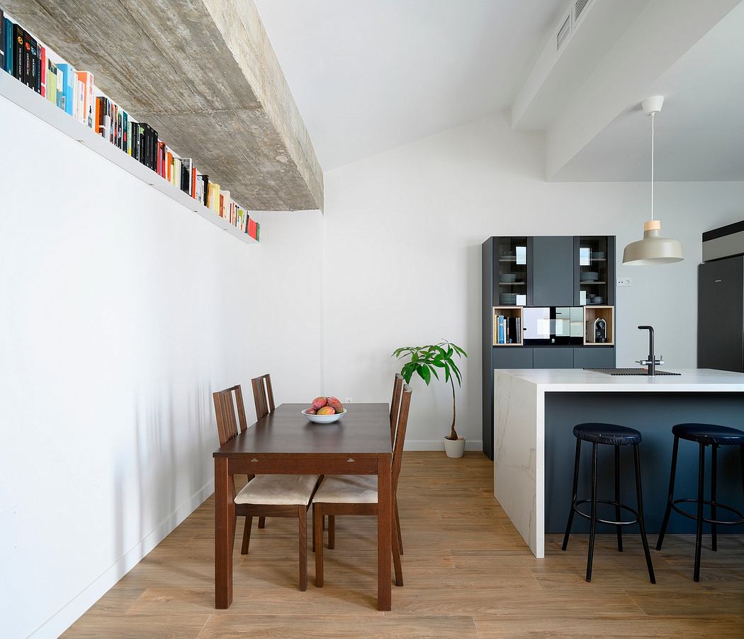 Minimalist kitchen-dining area with concrete ceiling, built-in shelving, and wooden furniture.