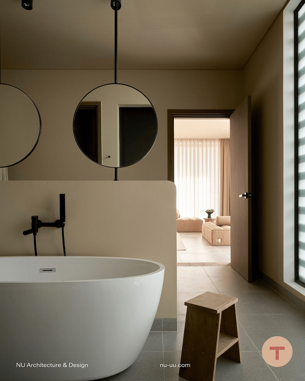 Elegant bathroom with freestanding tub, round mirrors, and a view to the living room beyond.