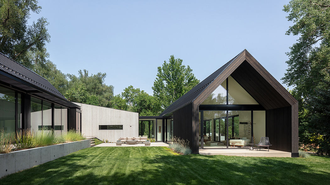 Modern one-story home with sharp roof angles, large windows, and manicured lawn.