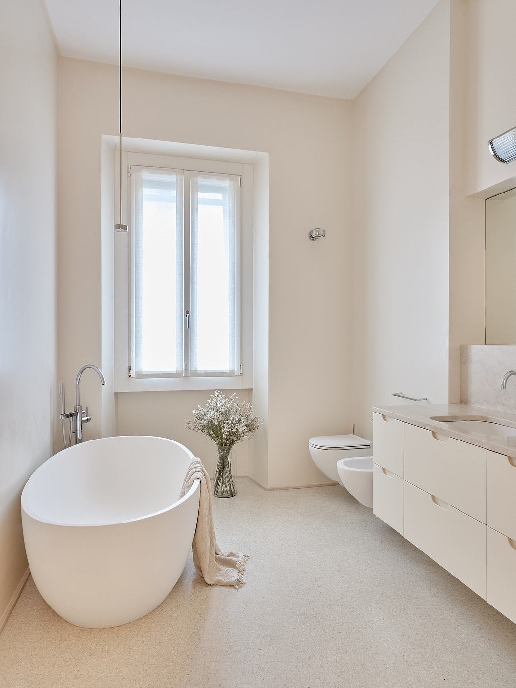 Bright, modern bathroom with freestanding tub, vanity, and large window.