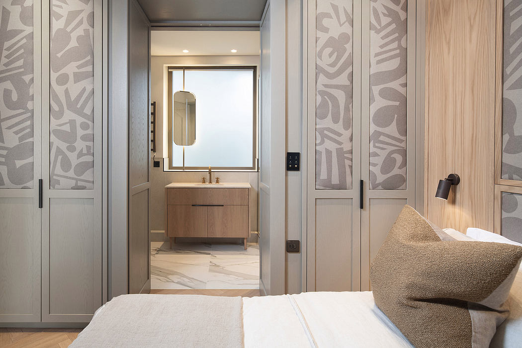 A modern bedroom with sleek, geometric wall panels and an open en-suite bathroom.