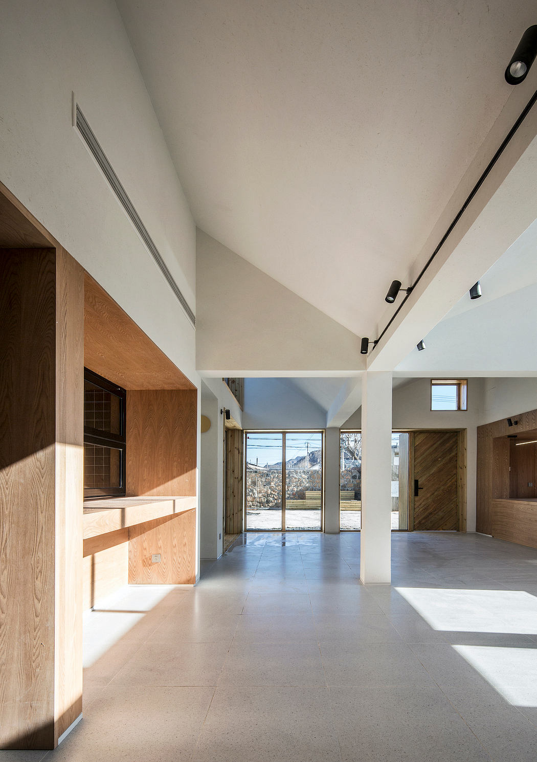 Bright, modern interior with wooden accents, large windows, and concrete floors.