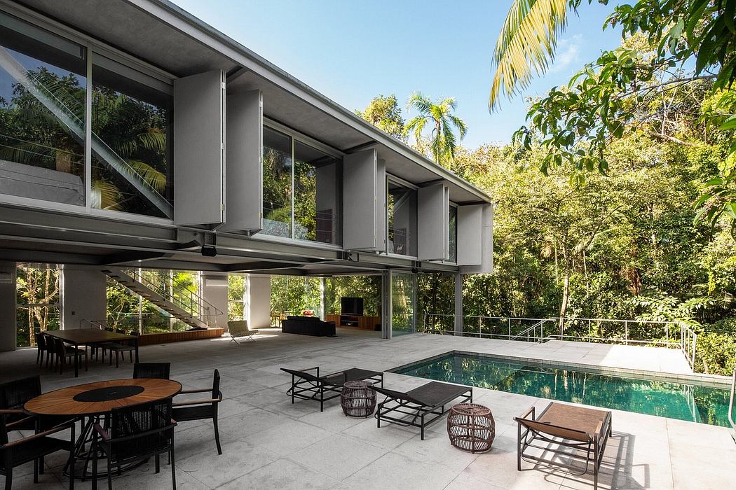 Sleek, modern architecture with an inviting poolside terrace surrounded by lush greenery.