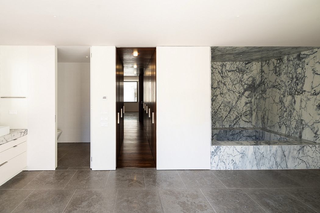 Elegant modern interior with marble walls, wood floors, and recessed lighting.