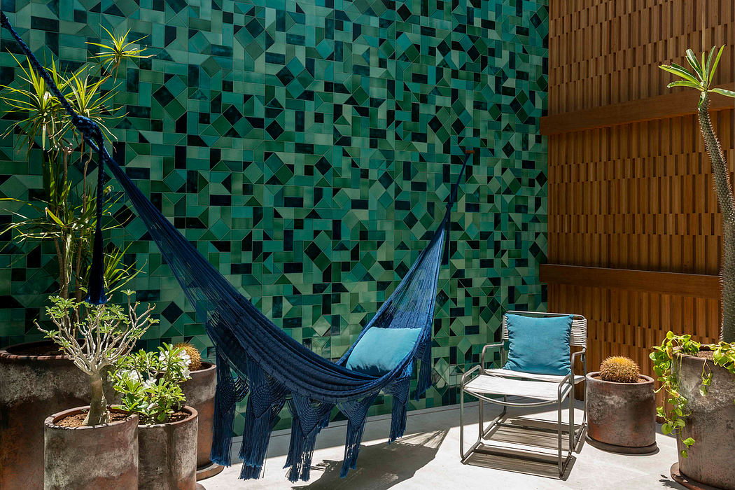 A vibrant, geometric tiled wall contrasts with wooden paneling and a cozy blue hammock.