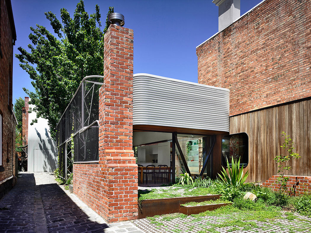 Striking brick and steel architectural elements, with a modern glass entryway and lush landscaping.