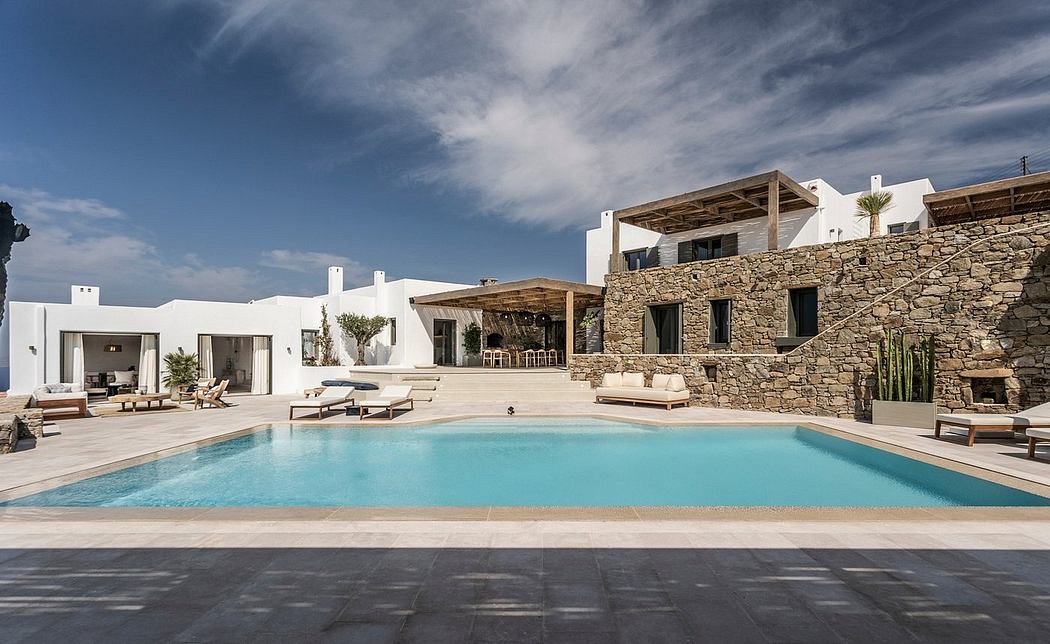 Stunning Mediterranean-style villa with a large pool, sun loungers, and a stone exterior.