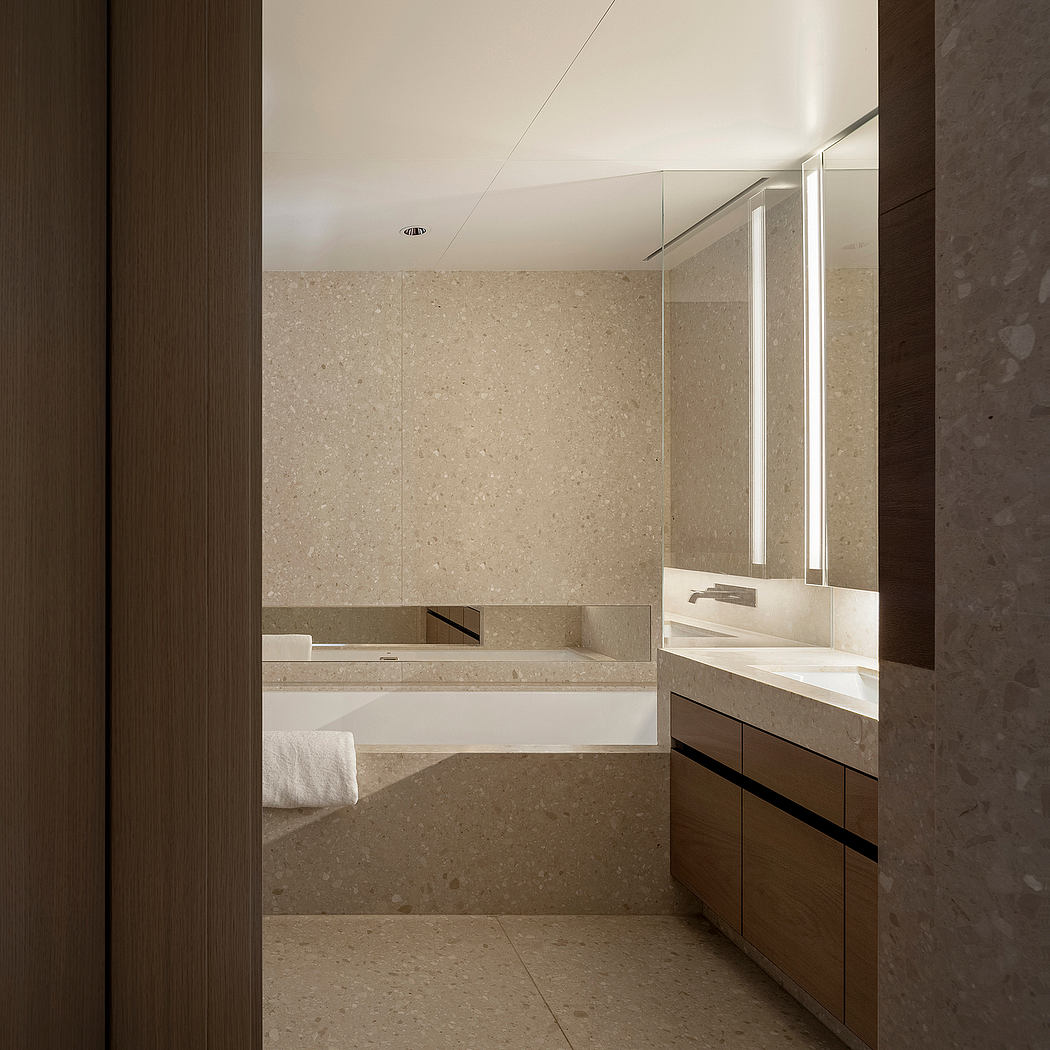 Minimalist bathroom design with beige-toned stone tiles, understated vanity, and recessed lighting.