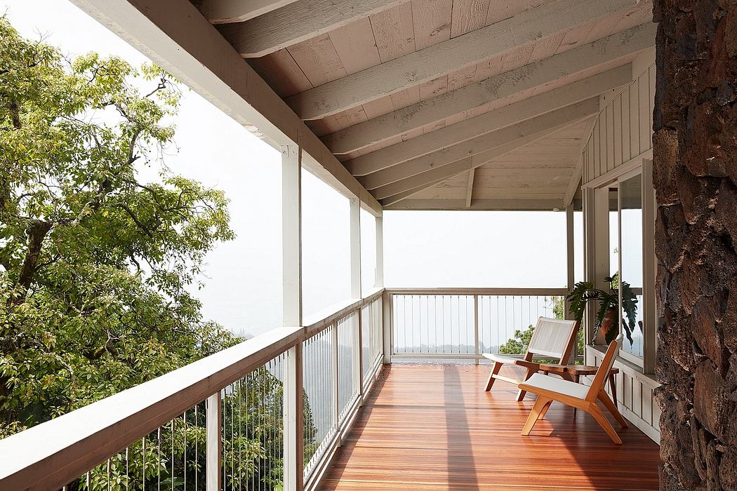 Wooden porch with railing overlooking lush greenery, showcasing rustic architecture.
