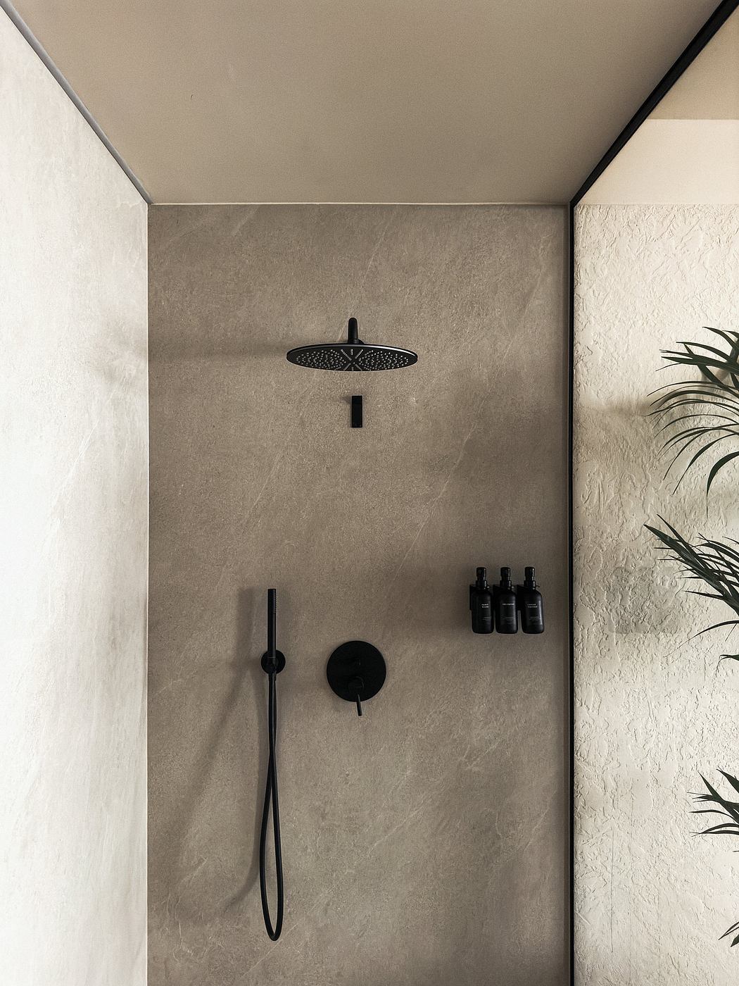 Modern minimalist shower with sleek black fixtures and neutral-toned tiles.