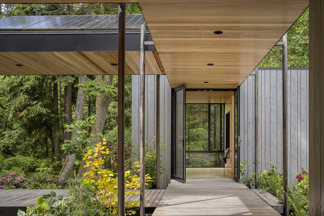 Sleek modern structure with glass walls, wood accents, and lush natural surroundings.