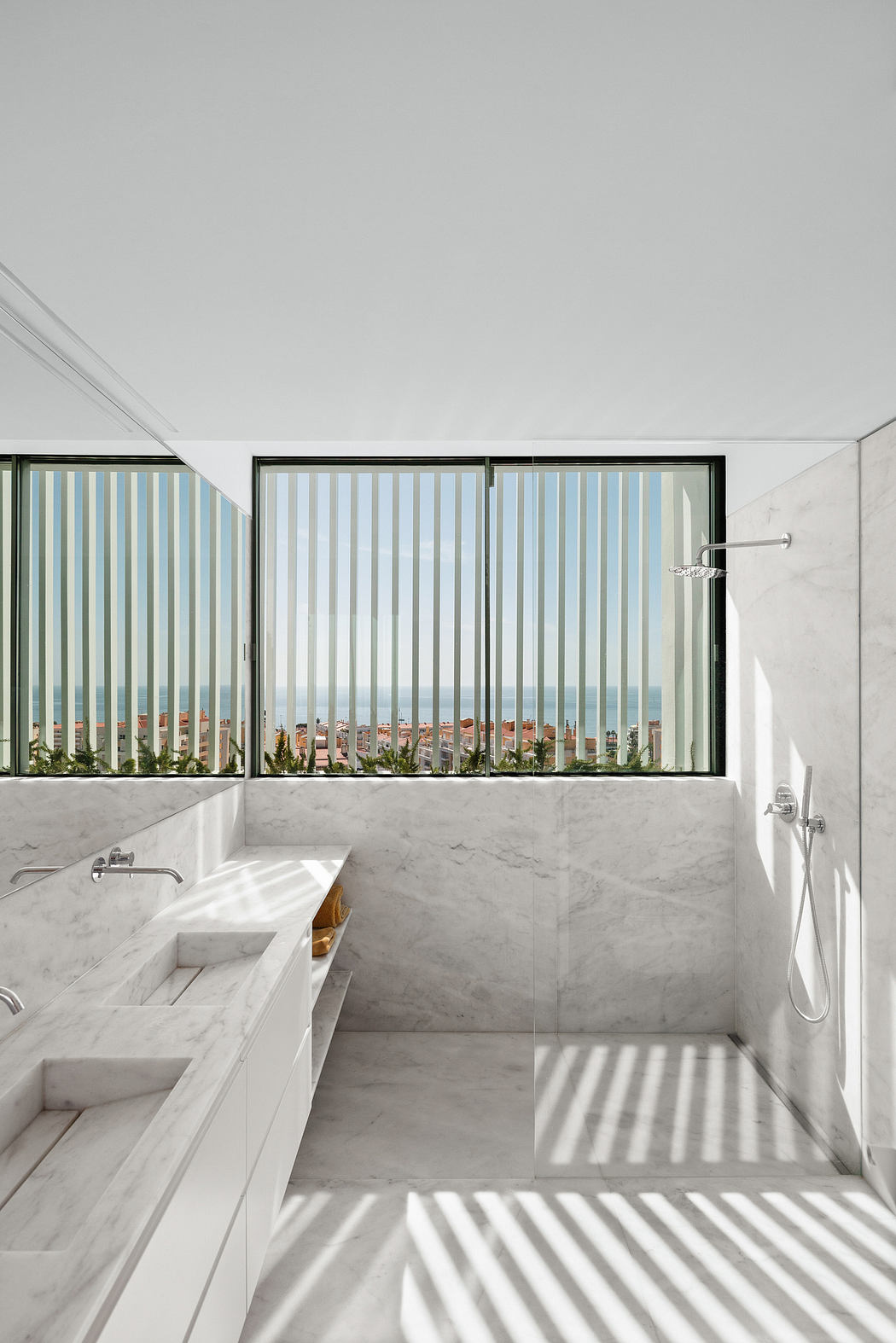 A bright, airy bathroom with floor-to-ceiling windows offering a panoramic city view.