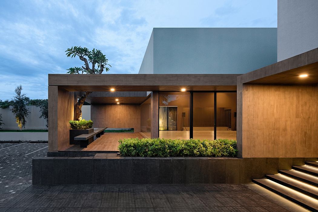 A modern and minimalist architectural design with a wooden exterior, glass walls, and a small garden.
