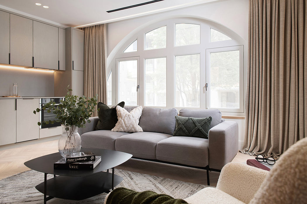 Elegant living room with arched windows, sleek gray sofa, and modern decor.