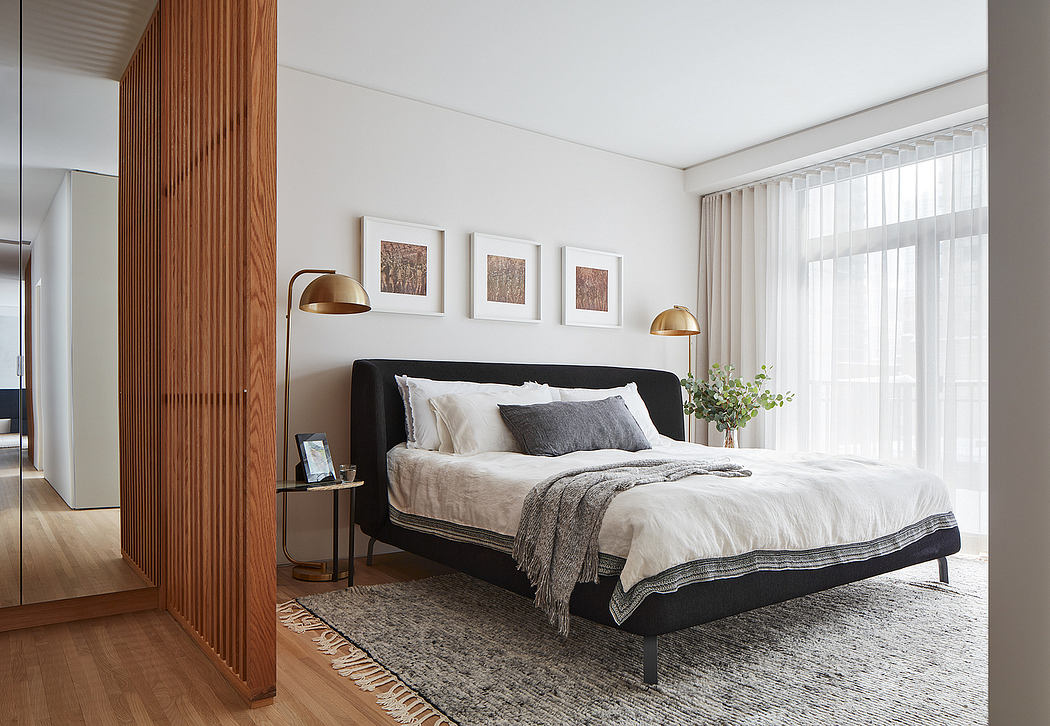Elegant bedroom with wood paneling, black bed frame, and framed artwork.