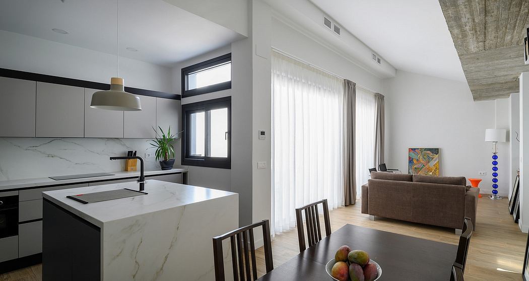 Spacious, modern kitchen with marble countertops, black faucet, and open-concept living room.