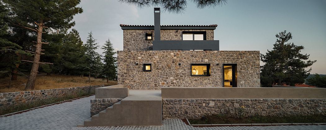 A modern, stone-clad house with large windows and a sleek, minimalist design.