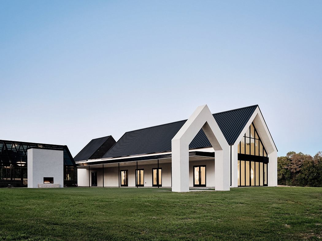 Striking modern architecture with black metal roofs, white walls, and large windows.