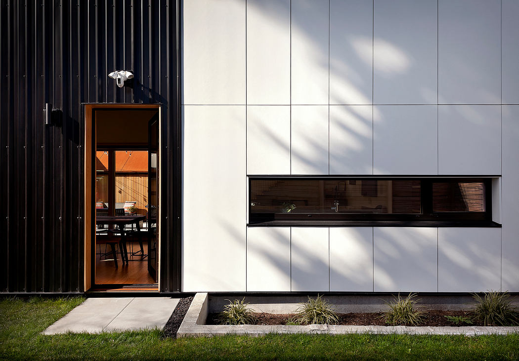 Sleek, modern facade with wooden accents and recessed windows; minimalistic landscaping.
